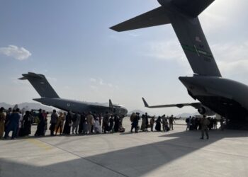 Orang-orang mengantre untuk menaiki sebuah pesawat militer Amerika Serikat dan meninggalkan Kabul di bandara Kabul, Afghanistan, pada 22 Agustus 2021. (Xinhua)
