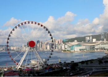 Foto yang diabadikan pada 8 Juli 2021 ini menunjukkan pemandangan sebuah bianglala dan Hong Kong Convention and Exhibition Center di Hong Kong, China selatan. (Xinhua/Wu Xiaochu)