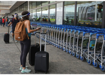 Wisatawan mendorong koper mereka di luar area keberangkatan Bandara Changi di Singapura pada 19 Agustus 2021. (Xinhua/Then Chih Wey)