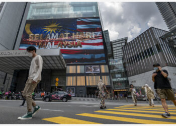 Orang-orang yang mengenakan masker melintas di sebuah jalan di Kuala Lumpur, Malaysia, pada 15 September 2021. (Xinhua/Chong Voon Chung)