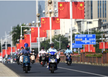 Orang-orang berkendara melintasi Jembatan Nanhu di Nanning, Daerah Otonom Etnis Zhuang Guangxi, China selatan, pada 29 September 2021. (Xinhua/Lu Boan)