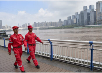 Sejumlah staf tanggap darurat berpatroli di sepanjang tepi Sungai Yangtze di Kota Chongqing, China barat daya, pada 7 September 2021. (Xinhua/Wang Quanchao)