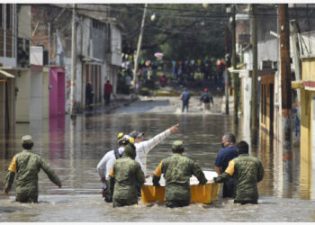 Tim penyelamat berjalan melewati jalan yang tergenang air di Tula, Negara Bagian Hidalgo, Meksiko, pada 7 September 2021. (Xinhua/Francisco Villeda)