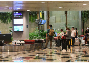 Para pelancong yang menaiki penerbangan Singapore Airlines SQ325 mengambil koper di area pengambilan bagasi di Bandar Udara Changi Singapura pada 8 September 2021. (Xinhua/Then Chih Wey)