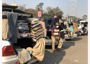 Seorang pria duduk di bagasi mobil yang menjual pakaian di Harare, Zimbabwe, pada 22 September 2021. Toko keliling telah menjadi pemandangan lazim di Harare setelah dampak pandemi COVID-19 pada perekonomian memaksa banyak orang melakukan perdagangan informal. (Xinhua/Tafara Mugwara)
