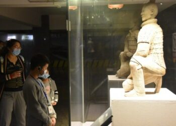 Para pengunjung yang memakai masker mengamati sebuah benda pameran di Museum Situs Mausoleum Kaisar Qinshihuang di Xi'an, Provinsi Shaanxi, China barat laut, pada 25 Maret 2020. (Xinhua/Yang Yimiao)