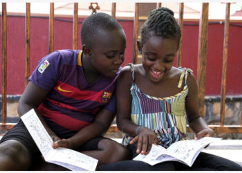 Anak-anak membaca buku cerita di rumah di Seguku, Distrik Wakiso, Uganda, pada 8 September 2021. (Xinhua/Hajarah Nalwadda)