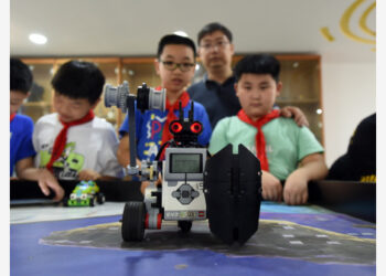 Yang Sen (kedua dari kanan) mengajar murid-muridnya di klub robot di Sekolah Dasar (SD) Heping di Kota Hefei, Provinsi Anhui, China timur, pada 8 September 2021. Yang Sen, seorang guru komputer dari SD Heping, tertarik mempelajari bahasa grafis yang digunakan pada robot dalam waktu luangnya. Setelah kelas usai, dia membentuk sebuah klub robot dan mengajarkan murid-muridnya untuk mengeksplorasi penggunaan berbagai sensor dan penerapan sejumlah prinsip ilmiah. (Xinhua/Zhou Mu)