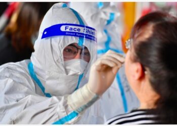 Seorang staf mengambil sampel usap (swab) untuk tes asam nukleat di sebuah lokasi pengujian di Distrik Siming yang berlokasi di Xiamen, Provinsi Fujian, China tenggara, pada 22 September 2021. (Xinhua/Jiang Kehong)