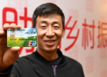 Seorang petani menunjukkan kartu debit bertema revitalisasi pedesaan yang diluncurkan oleh Bank Pertanian China di wilayah Yijun, Tongchuan di Provinsi Shaanxi, China barat laut, pada 29 April 2019. (Xinhua/Liu Xiao)