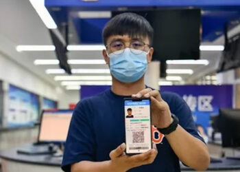 Seorang pria di China menunjukkan SIM digital di ponselnya. /ist