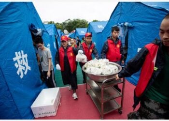 Para sukarelawan mengantarkan makanan di tempat penampungan sementara di Fuji di wilayah Luxian, Provinsi Sichuan, China barat daya, pada 16 September 2021. (Xinhua/Jiang Hongjing)