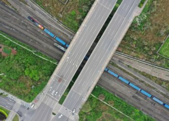 Foto dari udara yang diabadikan pada 19 Maret 2021 ini menunjukkan kereta barang China-Eropa Yuxinou (Chongqing-Xinjiang-Eropa) melintas di bawah sebuah jembatan di Kota Chongqing, China barat daya. (Xinhua/Tang Yi)