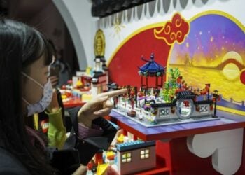 Pengunjung mengamati miniatur taman bergaya khas tradisional China yang dibangun menggunakan mainan Lego dalam Pameran Impor Internasional China (China International Import Expo/CIIE) ketiga di Shanghai, China timur, pada 8 November 2020. (Xinhua/Zhang Haofu)