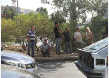 Para pengemudi mobil mengobrol sembari menunggu untuk mendapatkan bahan bakar di tepi jalan utama di dekat stasiun pengisian bahan bakar umum (SPBU) di Beirut, Lebanon, pada 21 September 2021. (Xinhua/Liu Zongya)