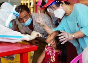 Tenaga kesehatan mengambil sampel usap dari seorang anak perempuan untuk tes asam nukleat di wilayah Xianyou, Kota Putian, Provinsi Fujian, China timur, pada 16 September 2021. (Xinhua/Wei Peiquan)