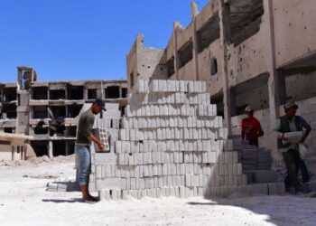 Para pekerja mengangkut batu bata untuk proyek rehabilitasi di pinggiran kota Daraya, sebelah barat ibu kota Damaskus, Suriah, pada 13 September 2021. (Xinhua/Ammar Safarjalani)