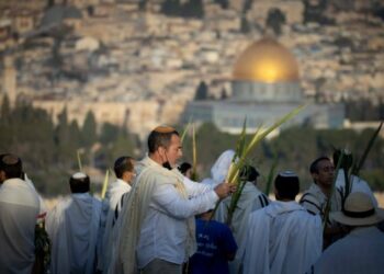 Pria-pria Yahudi yang mengenakan selendang doa melaksanakan ibadah Hoshana Rabbah pada hari ke-7 Sukkot di Bukit Zaitun, yang menghadap ke Kota Tua Yerusalem, pada 27 September 2021. (Xinhua/JINI)