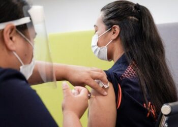 Seorang pekerja perbatasan menerima suntikan vaksin COVID-19 di Auckland, Selandia Baru, pada 20 Februari 2021. (Xinhua)