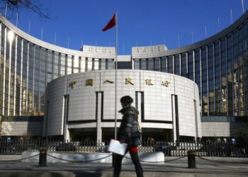 Foto dokumentasi ini menunjukkan seorang pejalan kaki melewati kantor pusat bank sentral China, People's Bank of China, di Beijing, ibu kota China. (Xinhua/Wan Xiang)