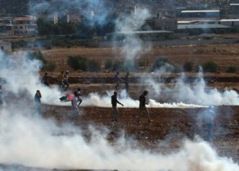 Para pengunjuk rasa Palestina berlarian untuk berlindung dari gas air mata yang ditembakkan oleh tentara Israel dalam sebuah aksi protes menentang perluasan permukiman Yahudi di Desa Beit Dajan, Nablus timur, di Tepi Barat, pada 22 Oktober 2021. (Xinhua/Nidal Eshtayeh)