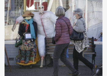 Orang-orang berjalan melewati orang-orangan sawah di depan sebuah toko di Desa Steveston di Richmond, British Columbia, Kanada, pada 6 Oktober 2021. (Xinhua/Liang Sen)