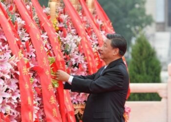 Xi Jinping meluruskan pita merah pada karangan bunga dalam upacara peletakan karangan bunga untuk mengenang para pahlawan nasional yang gugur di Lapangan Tian'anmen di Beijing, ibu kota China, pada 30 September 2021. (Xinhua/Zhang Ling)