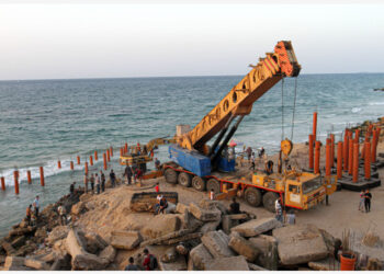 Para pekerja mengoperasikan buldoser untuk membangun kedai kopi "Citadel", pertama dari jenisnya yang dibangun di pantai, di Gaza City pada 27 Oktober 2021. (Xinhua/Rizek Abdeljawad)