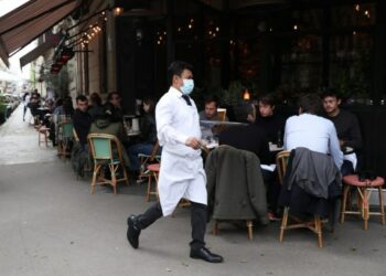 Seorang pelayan tampak sibuk di teras sebuah restoran pada hari pertama pembukaannya kembali di Paris, Prancis, pada 19 Mei 2021. (Xinhua/Gao Jing)