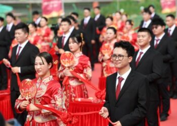 Sejumlah pasangan mengikuti upacara pernikahan massal di lokasi pembangunan jalur kereta ekspres di Nanning, Daerah Otonom Etnis Zhuang Guangxi, China selatan, pada 25 Oktober 2021. (Xinhua/Lu Boan)
