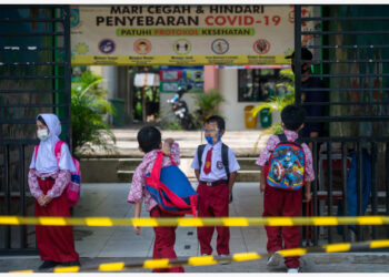 Para siswa SD yang mengenakan alat pelindung diri menunggu orang tua mereka menjemput di gerbang sekolah di Desa Babakan, Tangerang Selatan, pada 7 Oktober 2021. Jumlah kasus COVID-19 di Indonesia naik 1.393 dalam satu hari menjadi 4.224.487, dengan jumlah kematian bertambah 81 menjadi 142.494, kata Kementerian Kesehatan Republik Indonesia pada Kamis (7/10). (Xinhua/Veri Sanovri)