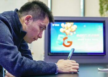 Foto dokumentasi ini menunjukkan seorang konsumen menjajal ponsel 5G di aula bisnis China Telecom Cabang Beijing di Beijing, ibu kota China. (Xinhua/Shen Bohan)