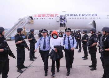 Polisi membawa para tersangka turun dari pesawat di Bandar Udara Internasional Ibu Kota di Beijing, ibu kota China, pada 7 Juni 2019. (Xinhua/Yin Gang)