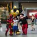 Seorang wisatawan berpose untuk difoto bersama karakter-karakter berkostum di Times Square di New York, Amerika Serikat, pada 2 Juli 2021. (Xinhua/Wang Ying)