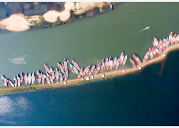 Foto dari udara yang diabadikan pada 24 Oktober 2021 ini memperlihatkan pemandangan perahu-perahu bermuatan batu di Sungai Jadukata di Sunamganj, Bangladesh. (Xinhua)