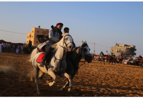 Para joki Palestina menunggangi kuda ketika mereka berpartisipasi dalam ajang balap unta dan kuda tradisional setempat di Kota Rafah, Jalur Gaza selatan, pada 24 Oktober 2021. (Xinhua/Khaled Omar)