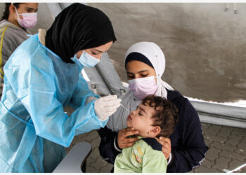 Seorang tenaga kesehatan mengambil sampel usap (swab) untuk tes COVID-19 dari seorang anak di Klinik Al-Shati yang berada di kamp pengungsi Al-Shati di Gaza City pada 7 Oktober 2021. (Xinhua/Rizek Abdeljawad)