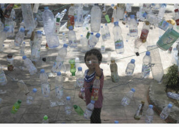Seorang bocah laki-laki mengamati sebuah instalasi yang terbuat dari botol-botol plastik dalam Marine Debris Festival, yang digelar oleh komunitas lokal sebagai kampanye untuk menyelamatkan pantai dari polusi plastik di Kabupaten Poliwali Mandar, Sulawesi Barat, pada 3 Oktober 2021. (Xinhua/Yusuf Wahil)