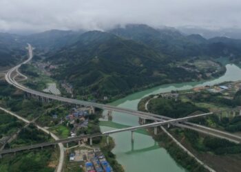 Foto dari udara yang diabadikan pada 20 Maret 2021 ini menunjukkan jalur air, jalan raya, dan jalur kereta di Wilayah Otonom Etnis Dong Sanjiang, Daerah Otonom Etnis Zhuang Guangxi, China selatan. (Xinhua/Zhou Hua)