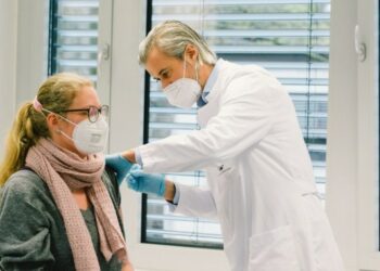Seorang tenaga kesehatan (kiri) menerima suntikan vaksin COVID-19 di Rumah Sakit Universitas Essen di Essen, Jerman, pada 18 Januari 2021. (Xinhua/Tang Ying)