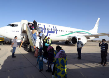 MISURATA, Sejumlah imigran ilegal mengantre untuk naik ke pesawat di Bandar Udara Internasional Misurata di Misurata, Libya, pada 3 November 2021. Sebanyak 91 imigran ilegal, yang sebagian besar merupakan anak-anak, pada Rabu (3/11) direpatriasi secara sukarela dari Libya ke negara asal mereka, Niger. (Xinhua/Hamza Turkia)