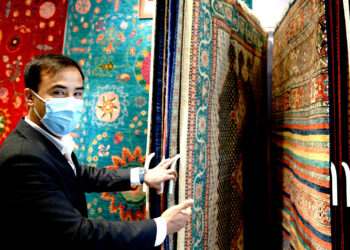 SHANGHAI, Ali Faiz, seorang pedagang karpet dari Afghanistan, memperkenalkan karpet-karpet wol buatan tangan di stannya dalam Pameran Impor Internasional China (China International Import Expo/CIIE) keempat di Shanghai, China timur, pada 6 November 2021. (Xinhua/Zhang Jiansong)
