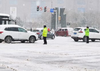 SHENYANG, Petugas polisi mengatur lalu lintas di tengah salju di Shenyang, Provinsi Liaoning, China timur laut, pada 8 November 2021. Badai salju yang berkepanjangan sejak Minggu (7/11) mengakibatkan rekor hujan salju, yang terbesar sejak 1905, di Shenyang, menurut otoritas meteorologi setempat pada Selasa (9/11). (Xinhua/Cui Kai)