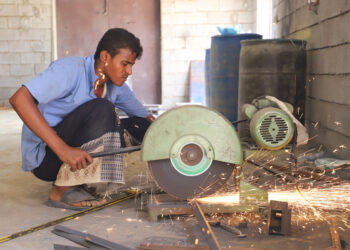 HAJJAH, Seorang pandai besi memotong material logam di sebuah bengkel kerja di Provinsi Hajjah, Yaman utara, pada 9 November 2021. Konflik selama bertahun-tahun telah menghancurkan perekonomian Yaman, dengan beberapa perusahaan dan pabrik besar masih beroperasi. (Xinhua/Mohammed Al-Wafi)