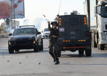 RAMALLAH, Seorang anggota kepolisian perbatasan Israel melempar kaleng gas air mata ke arah para pengunjuk rasa Palestina dalam bentrokan yang terjadi setelah pawai untuk memperingati 17 tahun kematian mendiang pemimpin Palestina Yasser Arafat di pos pemeriksaan Beit El di Israel, yang letaknya tak jauh dari Kota Ramallah di Tepi Barat, pada 11 November 2021. (Xinhua/Nidal Eshtayeh)