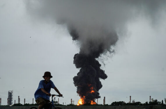 CILACAP, Asap tebal dan kobaran api membumbung dari sebuah tangki kilang minyak di Cilacap, Jawa Tengah, pada 14 November 2021. Sebuah tangki kilang minyak di Provinsi Jawa Tengah terbakar pada Sabtu (13/11) malam, penduduk yang tinggal di sekitar kilang itu akan dievakuasi sementara petugas pemadam kebakaran berjuang memadamkan api, kata perusahaan minyak dan gas negara PT Pertamina. Kilang Cilacap merupakan salah satu dari enam kilang minyak milik PT Pertamina. Kilang ini terdiri dari 200 tangki untuk minyak mentah yang akan diproses serta minyak dan gas dari pengolahan minyak mentah. (Xinhua/Anang Firmansyah)