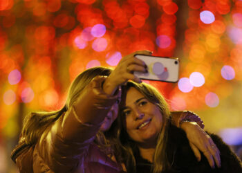 PARIS, Orang-orang berswafoto di Jalan Champs-Elysees di tengah gemerlap lampu-lampu Natal di Paris, Prancis, pada 21 November 2021. Acara penyalaan lampu musim Natal tahunan itu digelar di Paris pada Minggu (21/11). (Xinhua/Gao Jing)