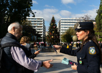 ATHENA, Seorang polisi wanita membagikan selebaran kepada pejalan kaki dalam Hari Internasional Penghapusan Kekerasan Terhadap Perempuan di Athena, Yunani, pada 25 November 2021. (Xinhua/Marios Lolos)