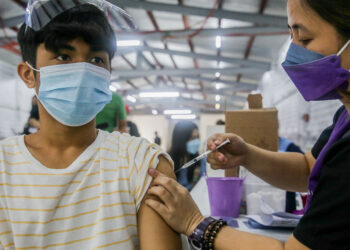 MARIKINA CITY, Seorang anak laki-laki menerima suntikan vaksin COVID-19 di sebuah kompleks olahraga di Marikina City, Filipina, pada 29 November 2021. Filipina pada Senin (29/11) memulai kampanye vaksinasi selama tiga hari untuk mempercepat imunisasi populasi negara itu terhadap COVID-19 dan varian Omicron. (Xinhua/Rouelle Umali)