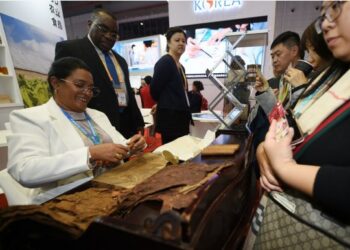 Seorang peserta pameran membuat cerutu di stan Kuba dalam ajang Pameran Impor Internasional China (China International Import Expo/CIIE) pertama di Shanghai, China timur, pada 6 November 2018. (Xinhua/Han Yuqing)